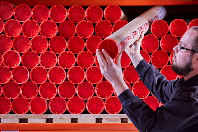 an image of a man inspecting a tube in a warehouse