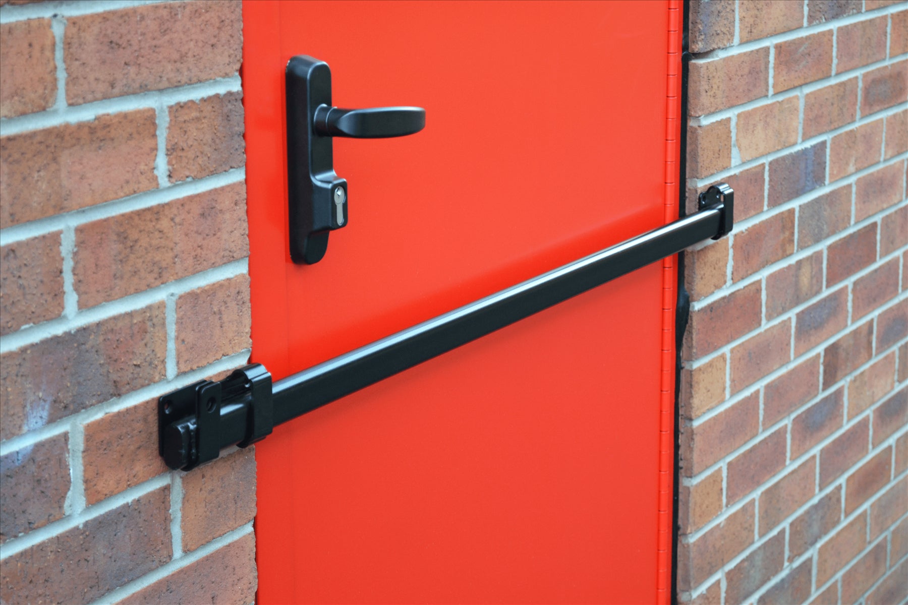 black steel Shed Security Bar, Garage and Garden Security on a red door and brick background